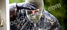Burglar looking in through shattered glass window Airdrie.