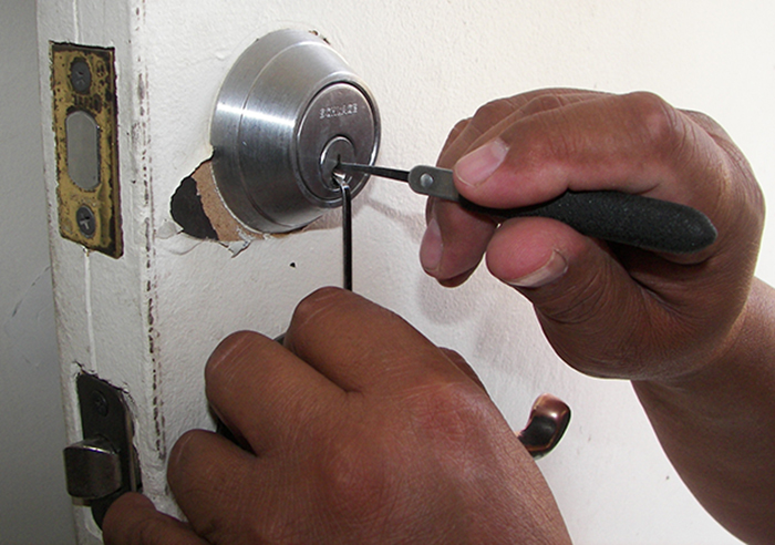 Locksmith picking door lock.