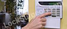 Person using a cell phone to adjust residential security panel Calgary.